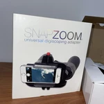 Snapzoom Universal Digiscoping Adapter For Smartphones With Box Open. Price: $22.00.